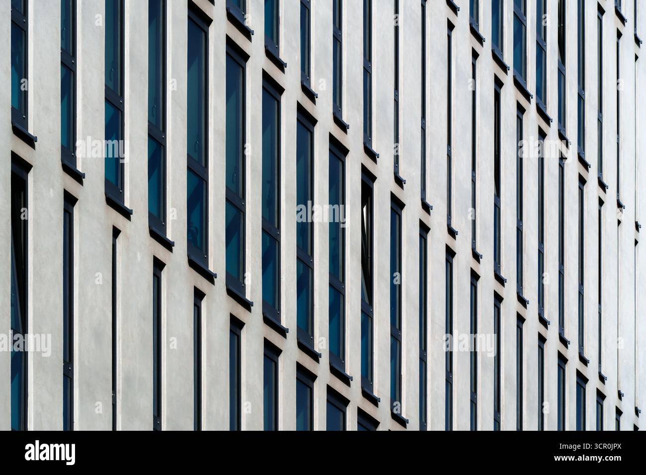 Moderno edificio di uffici con pannelli verticali geometrici bianchi e tonalità di colore in motivi ritmici Foto Stock