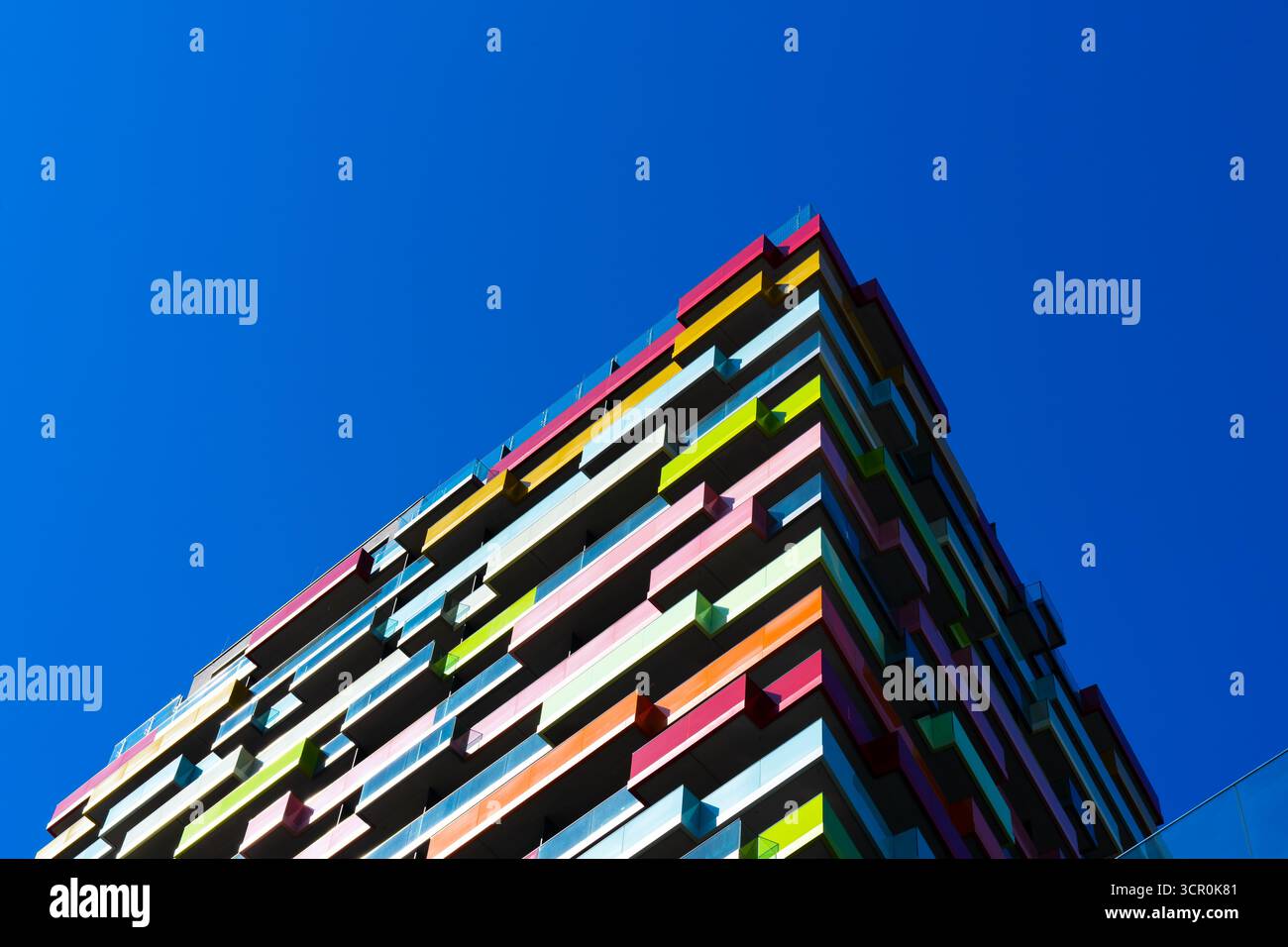 Edificio residenziale moderno e colorato con balconi geometrici e vibrante motivo della facciata che crea un ritmo architettonico dinamico Foto Stock