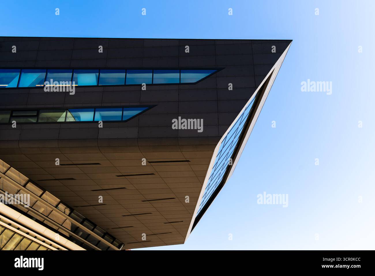 Architettura moderna della Biblioteca Universitaria di Vienna caratterizzata da una dinamica struttura in vetro a sbalzo sotto il cielo azzurro Foto Stock