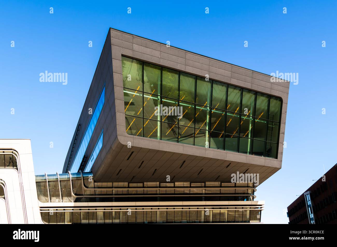 Architettura moderna della Biblioteca Universitaria di Vienna caratterizzata da una dinamica struttura in vetro a sbalzo sotto il cielo azzurro Foto Stock
