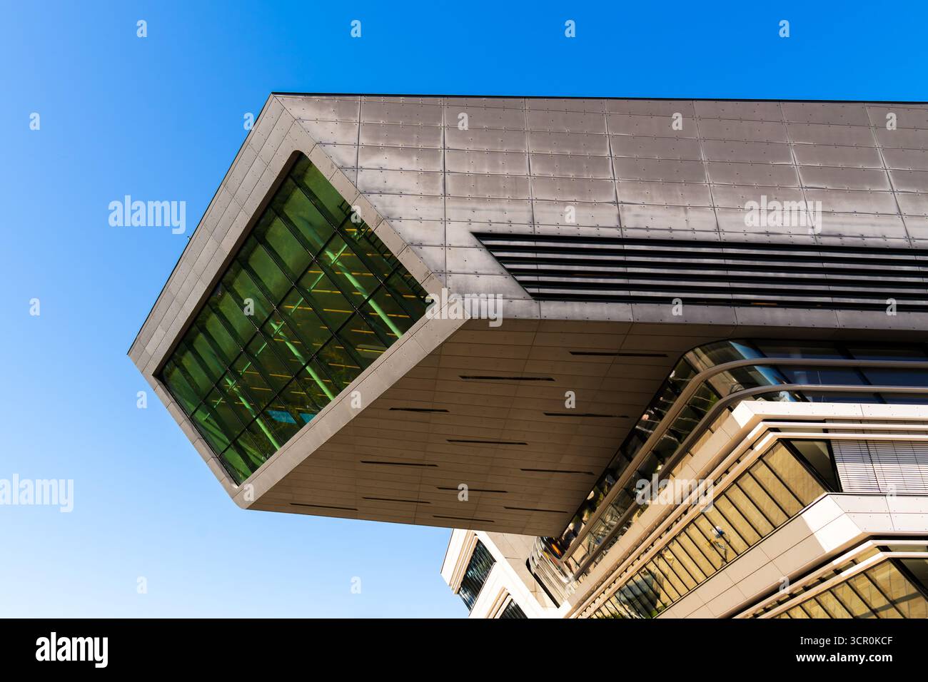 Architettura moderna della Biblioteca Universitaria di Vienna caratterizzata da una dinamica struttura in vetro a sbalzo sotto il cielo azzurro Foto Stock