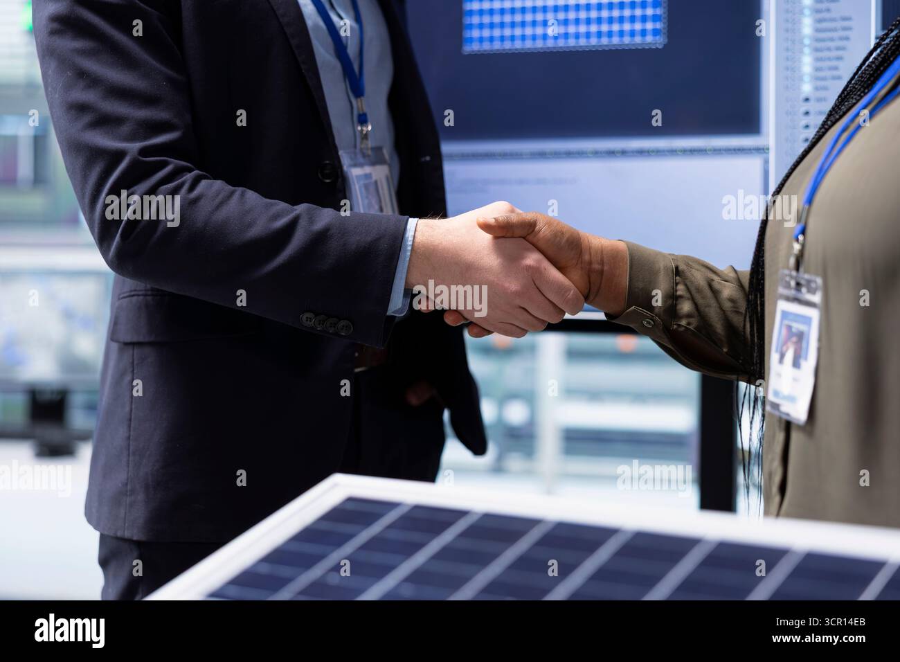 Gli investitori che si occupano di stretta di mano dopo aver esaminato la superficie del pannello solare sono soddisfatti dell'efficienza di progettazione. Uomini d'affari che stringono la mano, si incontrano per chiacchierare sui miglioramenti tecnici delle celle solari, primo piano Foto Stock