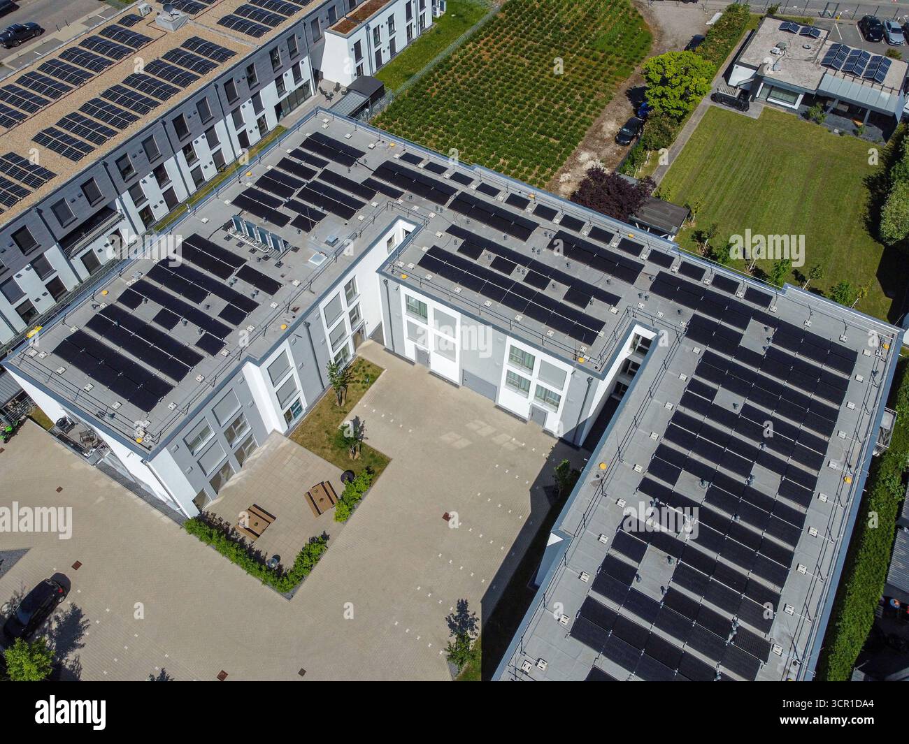 Vista aerea che mostra più pannelli solari installati su tetti piani di edifici contemporanei. Foto Stock