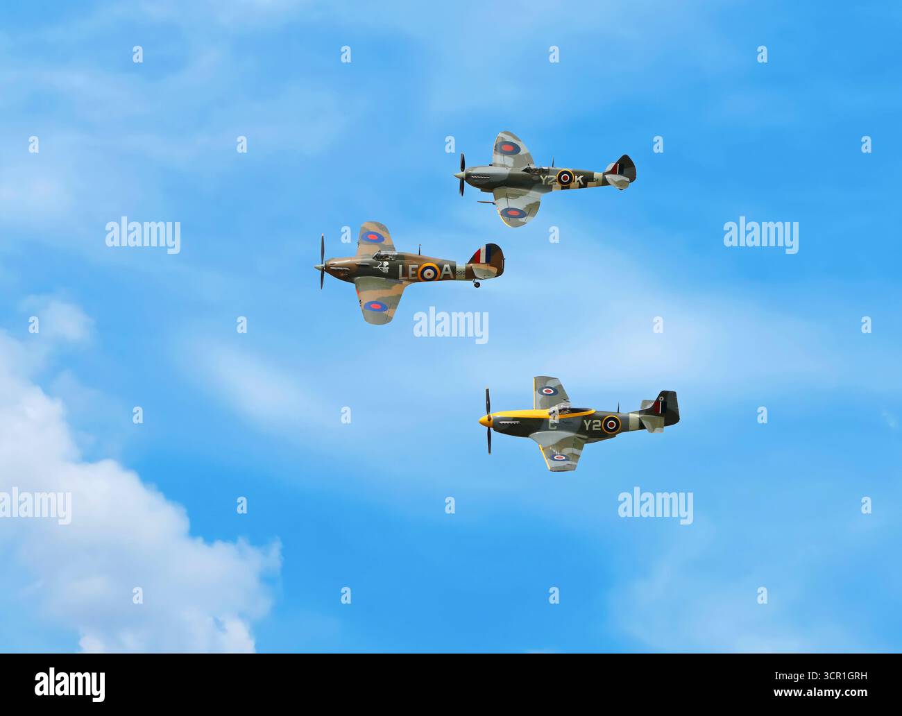 Supermarine Spitfire, Hawker Hurricane e aerei da caccia P-51D Mustang Air Force che eseguono figure acrobatiche su un cielo blu Foto Stock