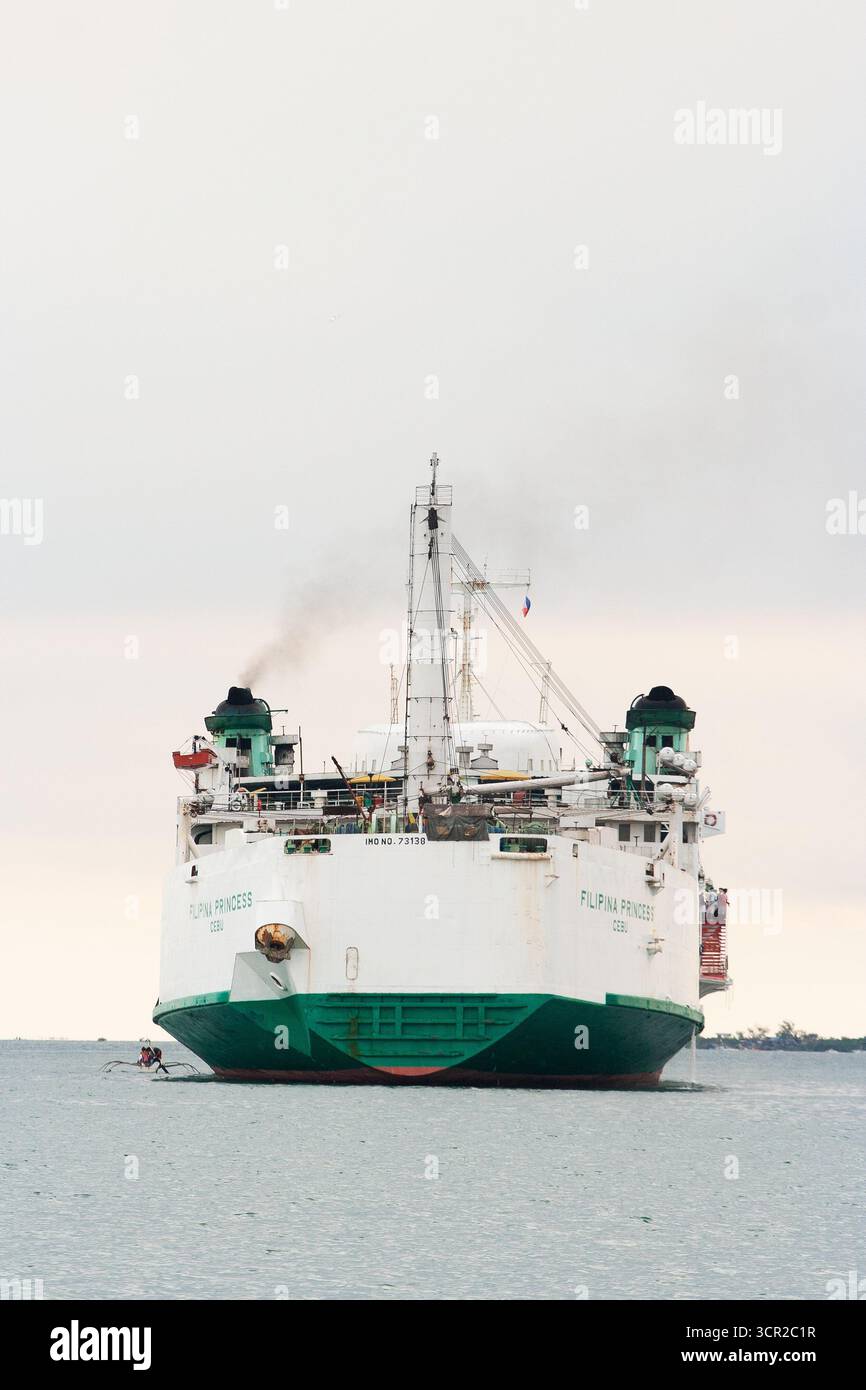 Una nave commerciale ancorata in mare al largo di Cebu City, Filippine Foto Stock