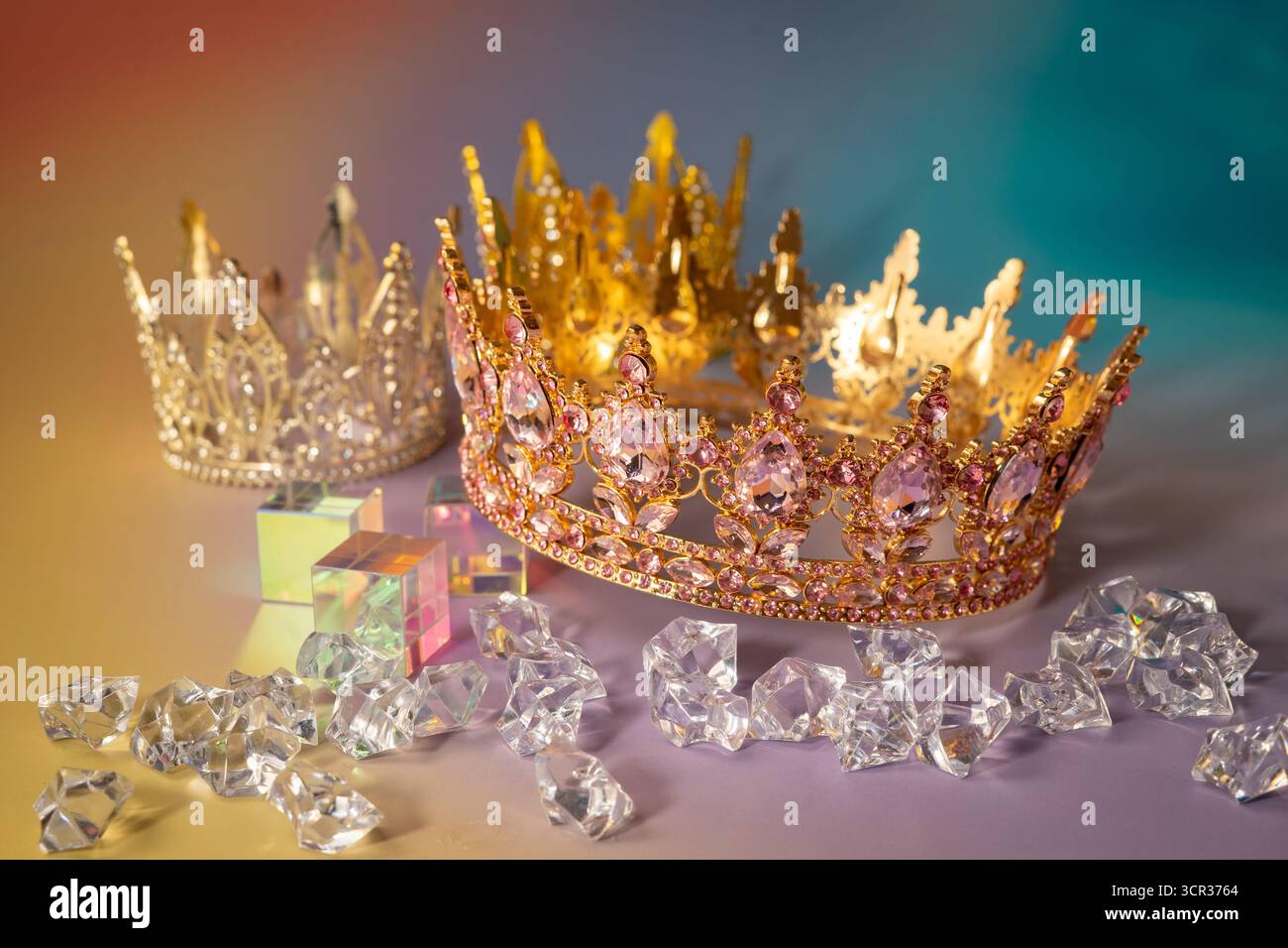 Corone d'oro e diamanti su un vivace sfondo arancione Foto Stock