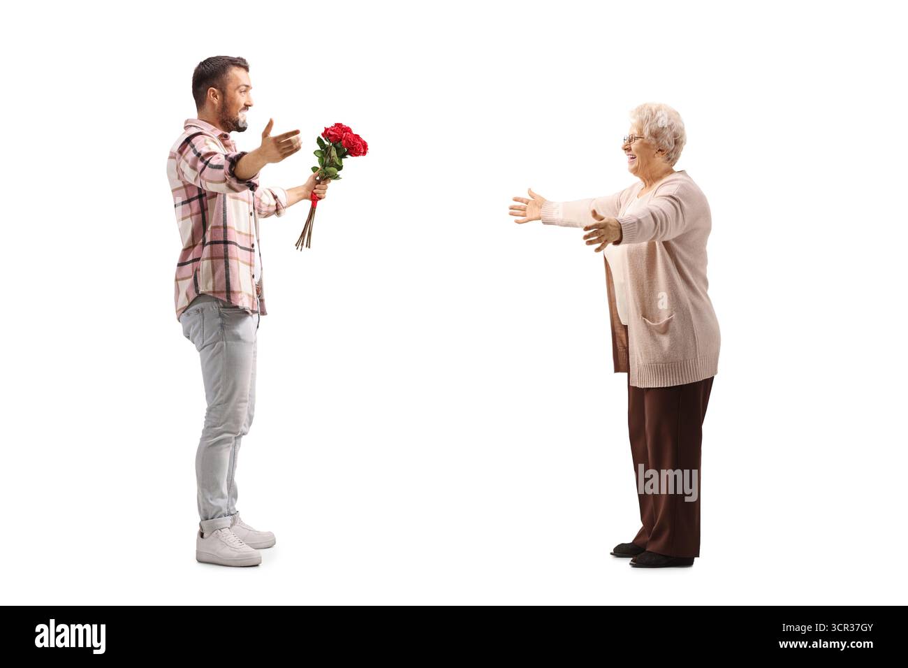 Foto a tutta lunghezza di un uomo che dona un mucchio di rose rosse a una donna anziana isolata su sfondo bianco Foto Stock