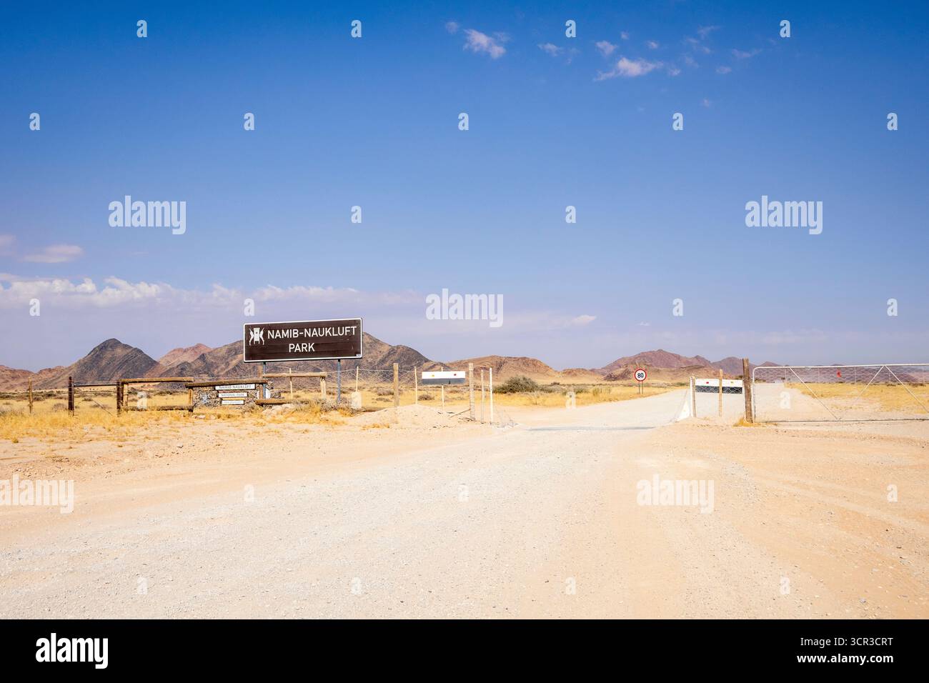 Cancello d'ingresso del Namib-Naukluft Park in Namibia - 27 agosto 2025: Con montagne sullo sfondo e una strada sterrata che conduce nel deserto. Foto Stock