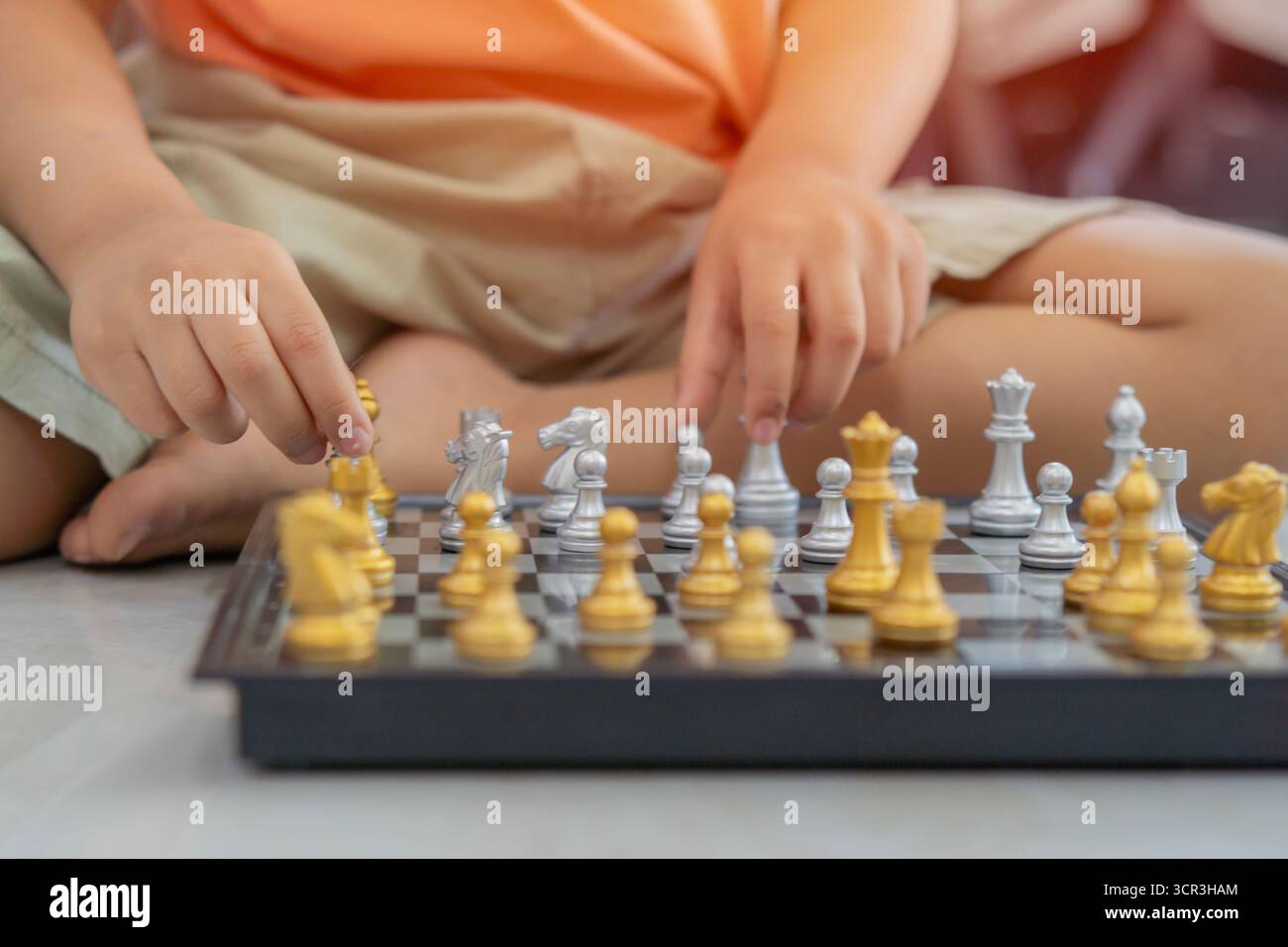 Il ragazzo ha preso il pezzo degli scacchi e fa la sua mossa. Sviluppo precoce, giochi educativi per bambini. Messa a fuoco selettiva. Foto Stock