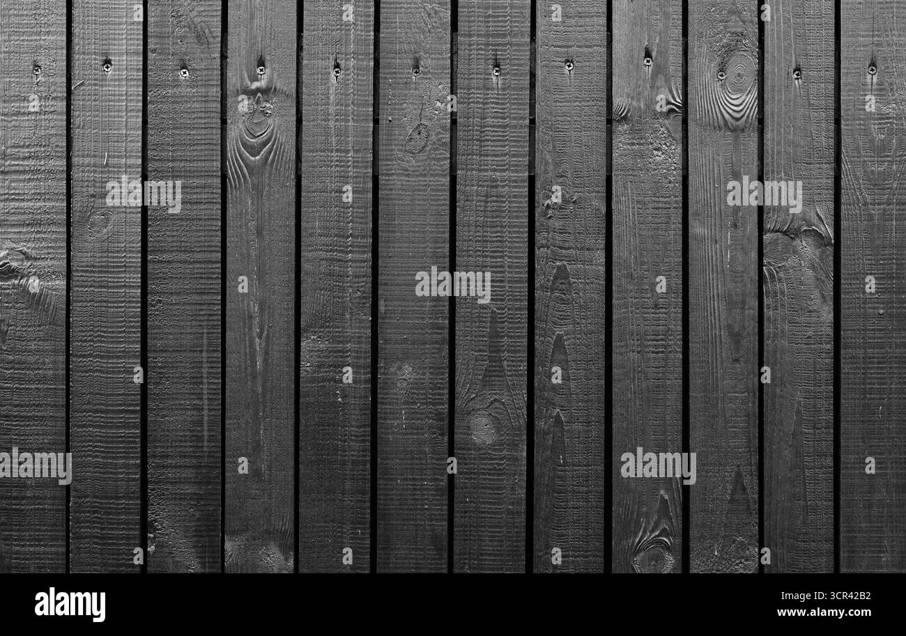Un'immagine dettagliata di tavole di legno nero con texture visibile, ideale per progetti rustici o a tema vintage, sfondi decorativi o applicazioni di design Foto Stock