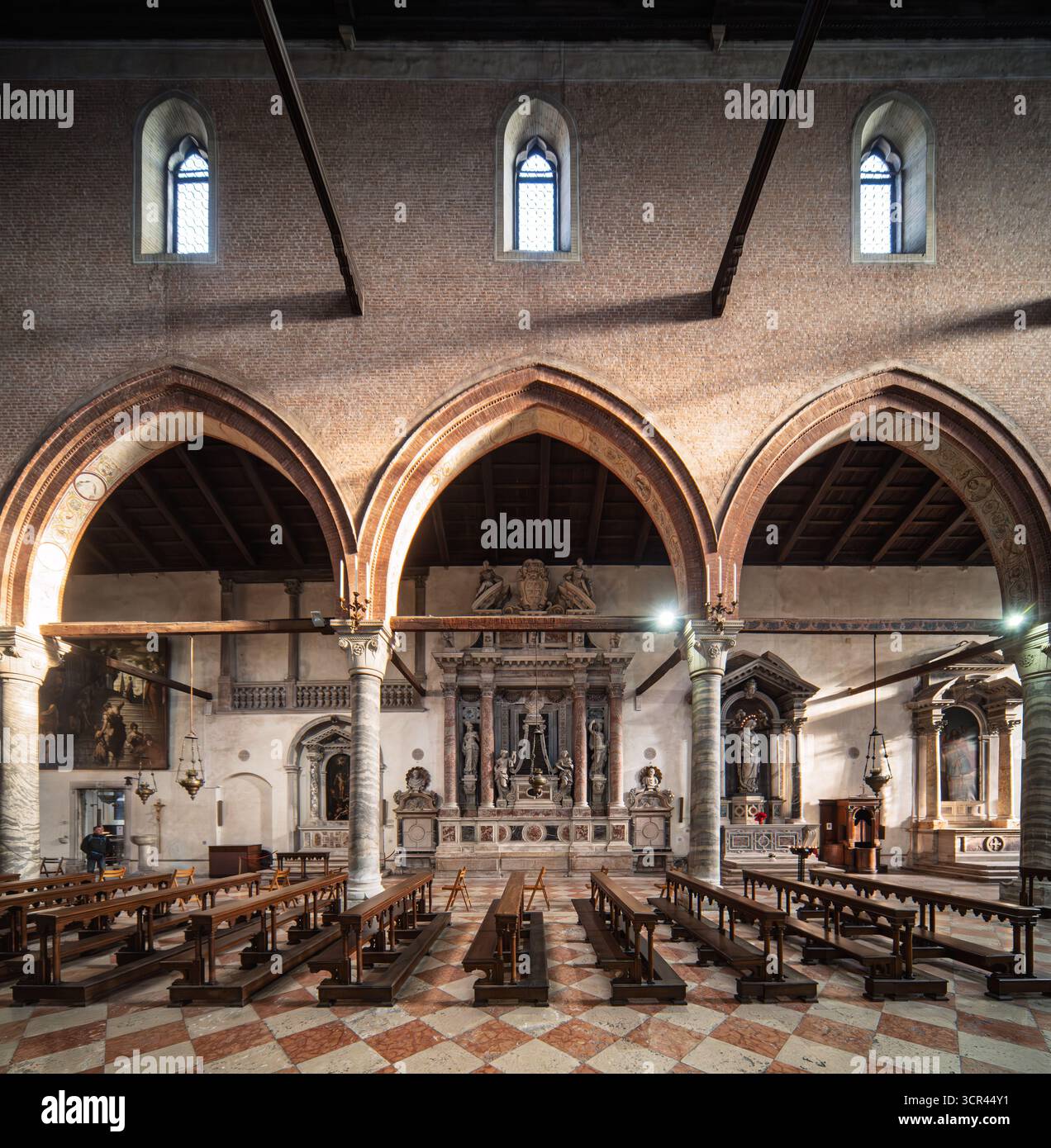 La luce soffusa del pomeriggio illumina il porticato della Madonna dell'Orto, con colonne in marmo, altari laterali e piastrelle a motivi geometrici a Cannaregio, Venezia Foto Stock