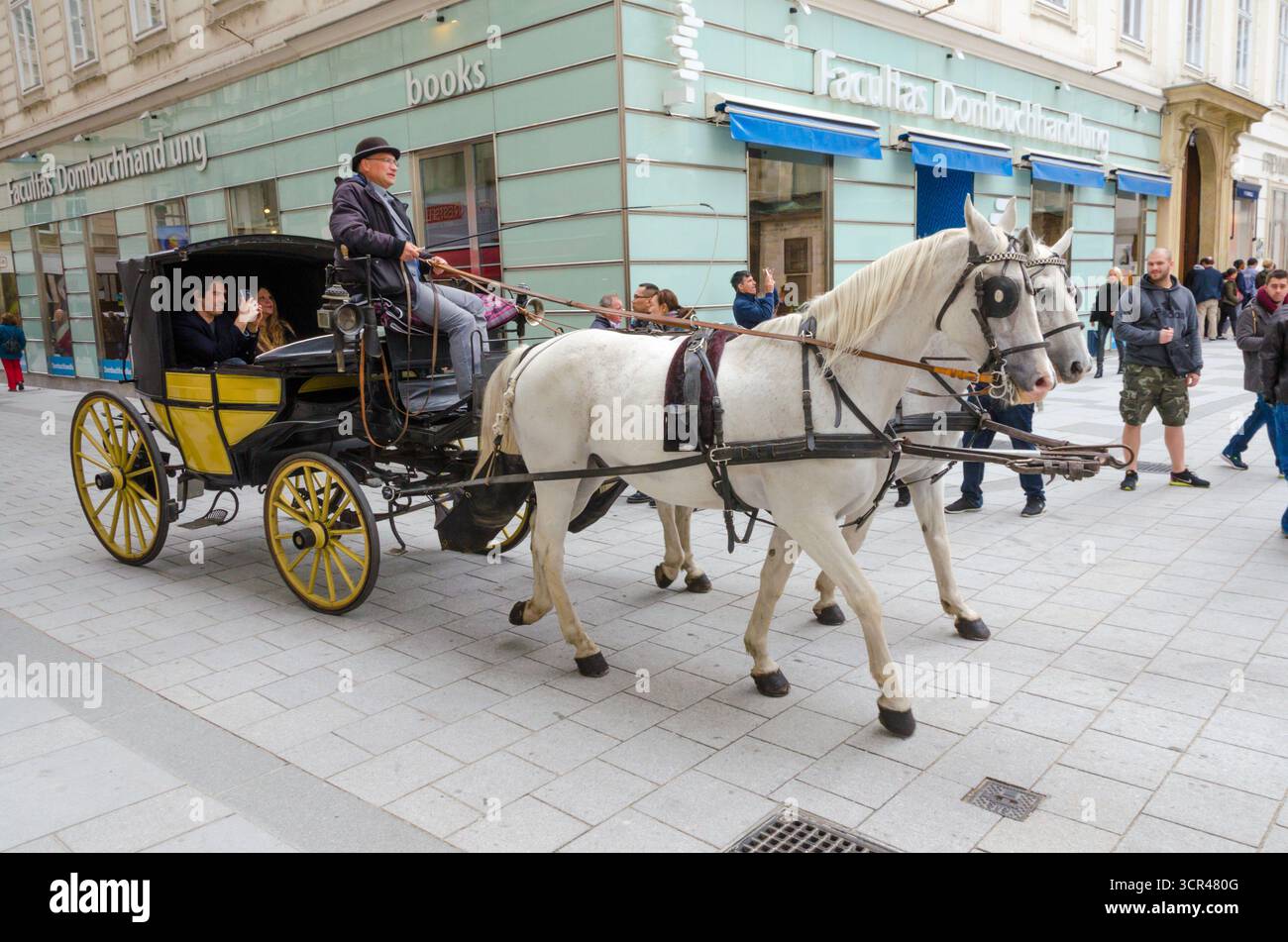 Vienna, Austria - 7 ottobre 2017: Tradizionale giro in carrozza trainata da cavalli con un cocchiere e turisti nel centro di Vienna. Foto Stock