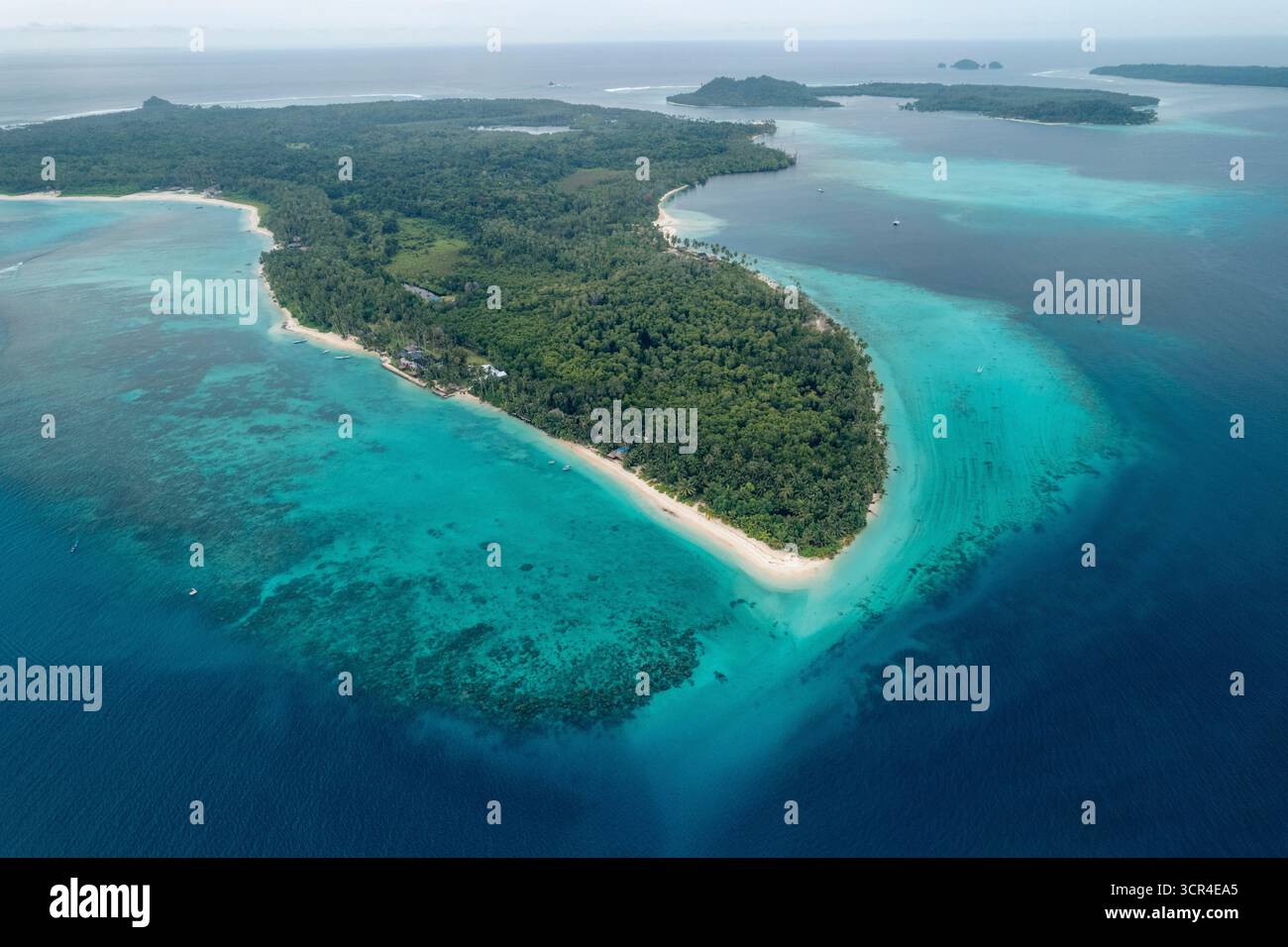 Vista aerea della lussureggiante isola verde circondata da acque turchesi dell'oceano con spiagge sabbiose. Zona del villaggio di Sipora, Mentawai, Sumatra occidentale, Indonesia Foto Stock