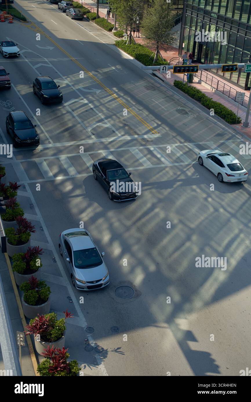 Vista aerea della strada della città con auto che proiettano ombre e la luce del sole che filtra attraverso la griglia dell'edificio. Miami, Florida, Stati Uniti Foto Stock