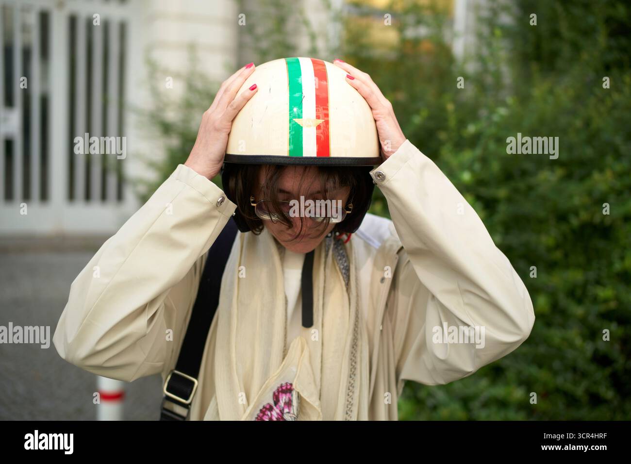 Casco da donna regolabile con strisce bandiera italiana all'aperto in una giacca leggera. Berlino, Germania Foto Stock
