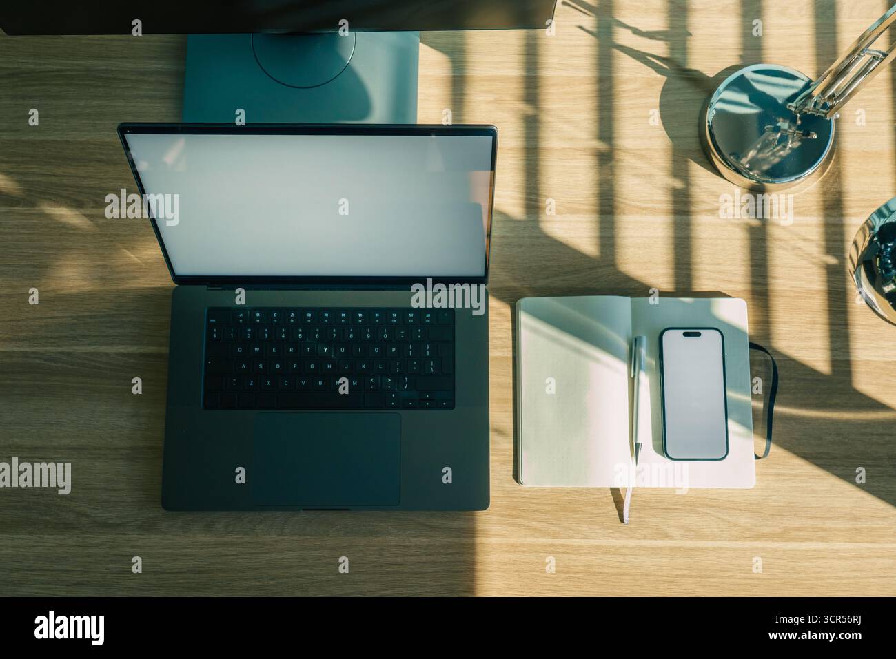 Workspace laptop notebook smartphone mockup con schermo dall'alto scrivania moderna organizzata con laptop aperto, notebook punteggiato, penna e smartphone Foto Stock