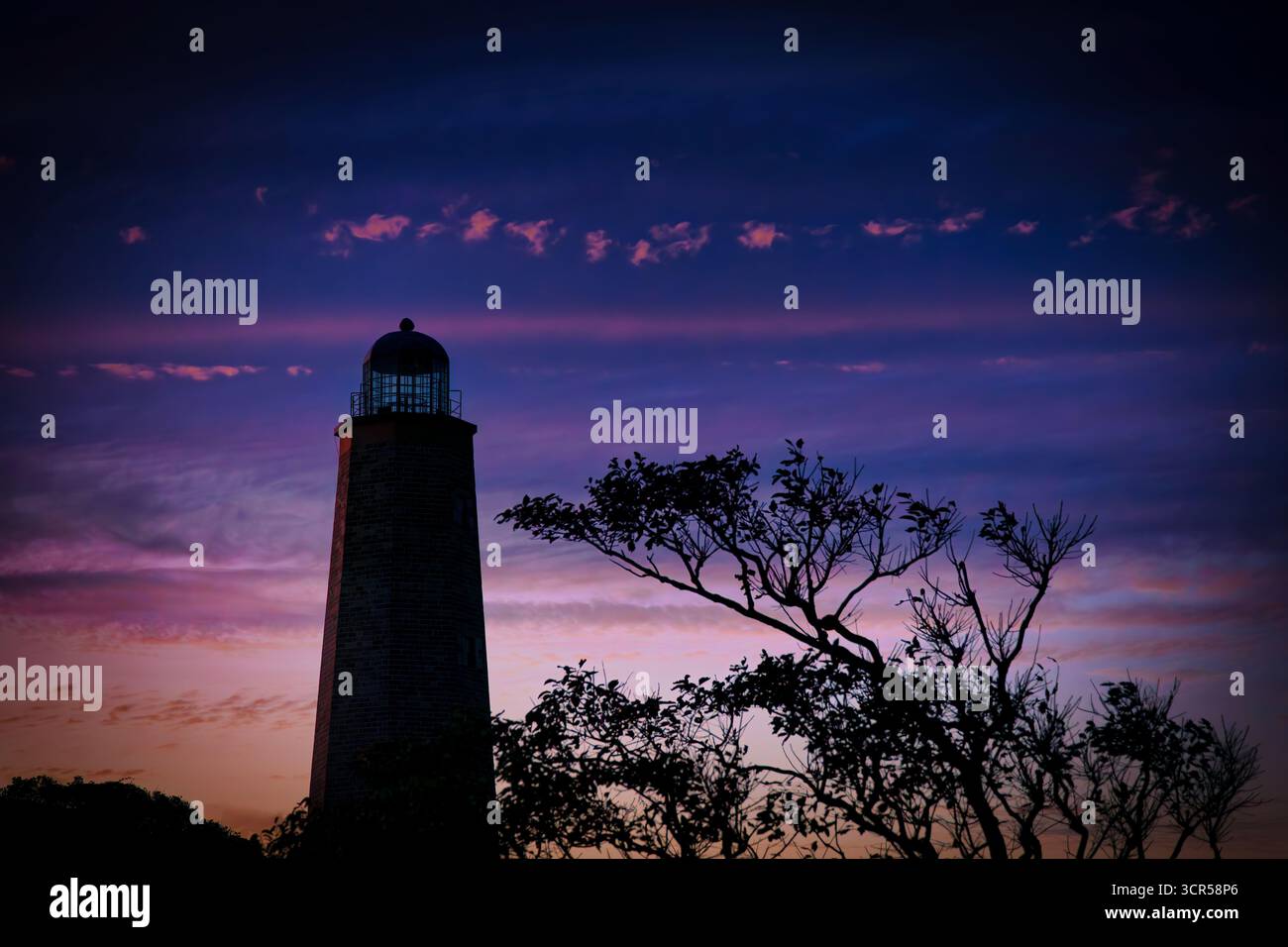 Il tramonto offre cieli colorati dietro il vecchio faro di Cape Henry, costruito nel 1792, a Virginia Beach, Virginia. Foto Stock
