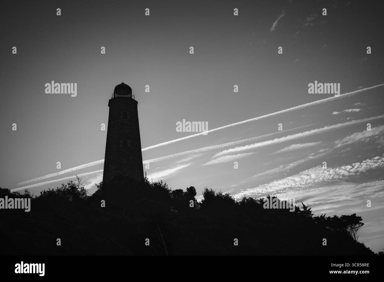Il sole della sera fornisce una sagoma del vecchio faro di Cape Henry, costruito nel 1792, a Virginia Beach, Virginia. Foto Stock