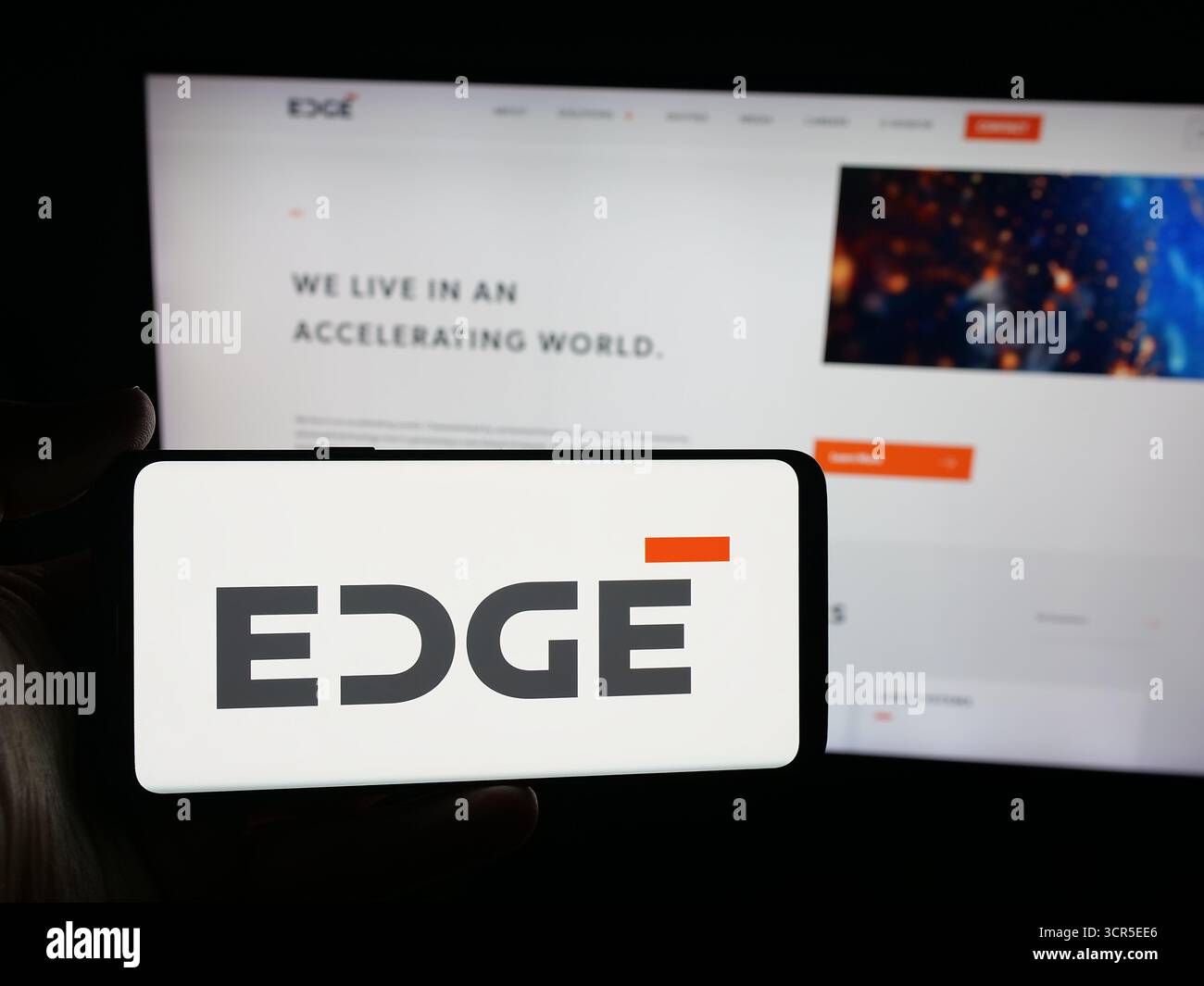 Stoccarda, Germania - 09-27-2025: Persona con smartphone con logo della società di difesa degli Emirati Edge Group PJSC sullo schermo davanti al sito Web. Foto Stock