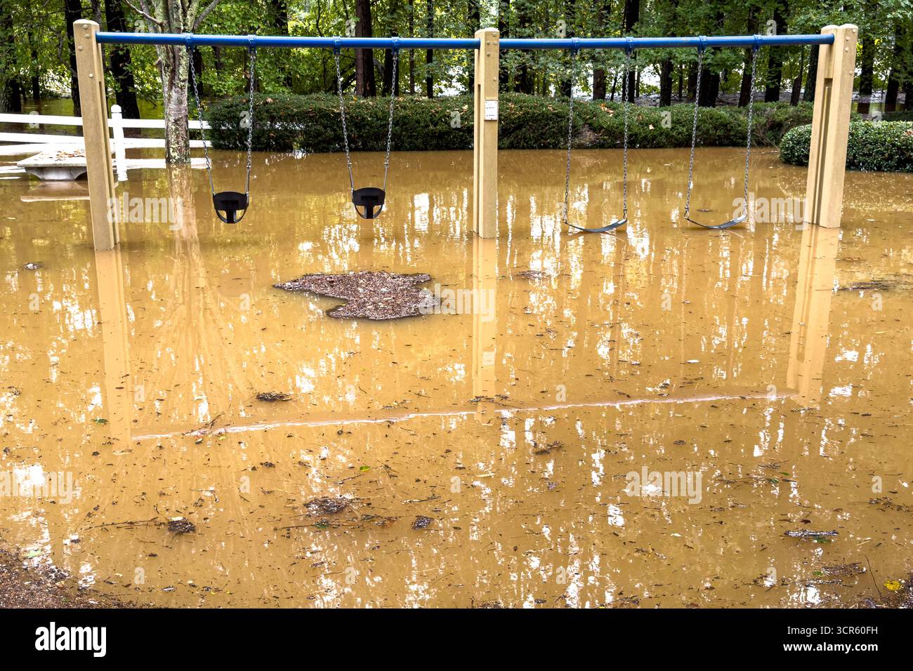 Un parco giochi con altalene in una comunità residenziale della Georgia, è sommerso dalle acque fangose dell'uragano Helene. Foto Stock