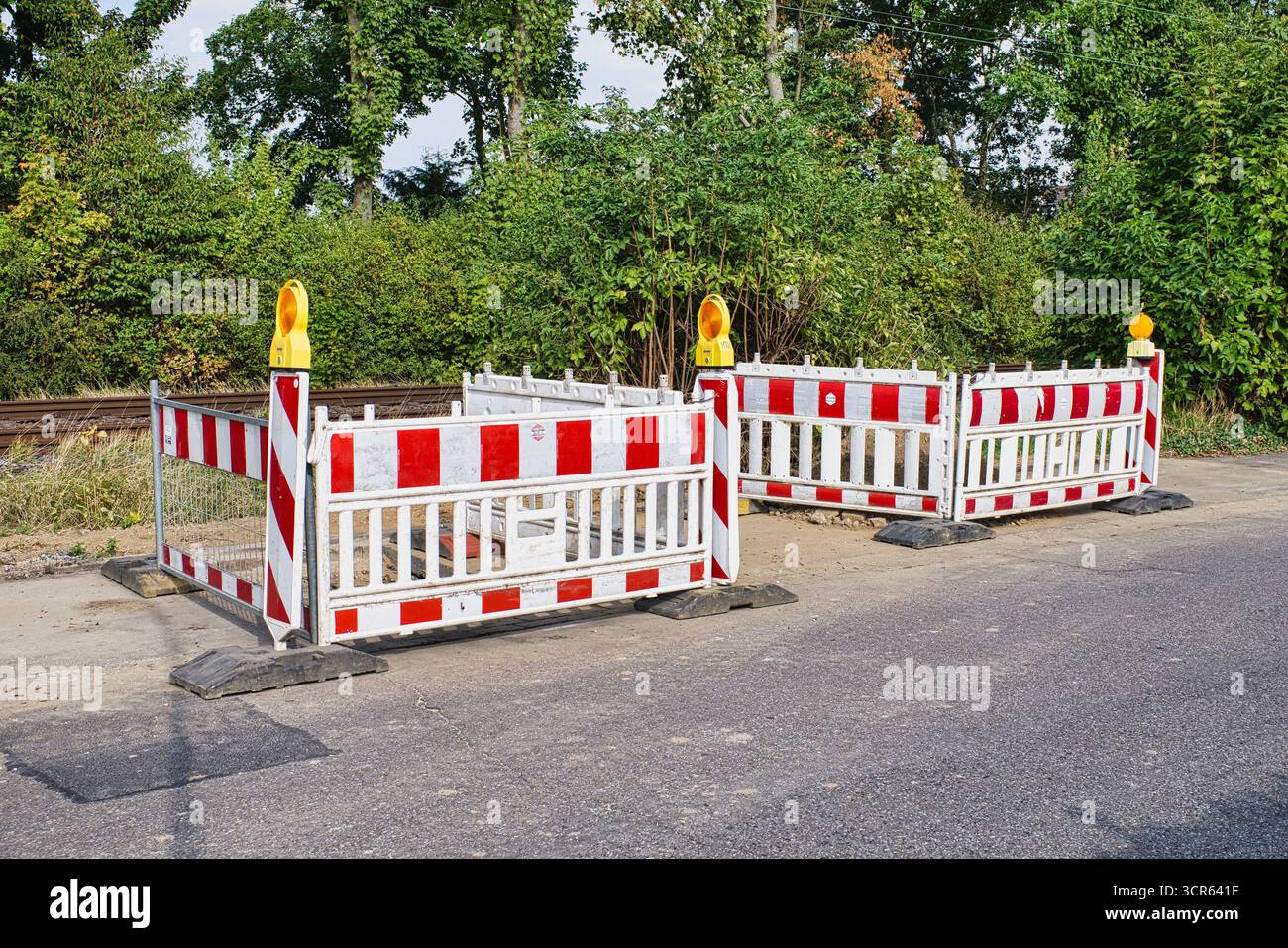 Barriere stradali con luci di sicurezza e segnaletica rossa bianca sulla strada Foto Stock