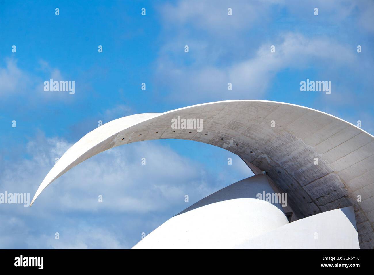 Struttura moderna in primo piano l'Auditorium "Adán Martín" di Tenerife ha un arco curvo in cemento contro un cielo blu con nuvole, l'architetto spagnolo Santiago Calatrava Foto Stock