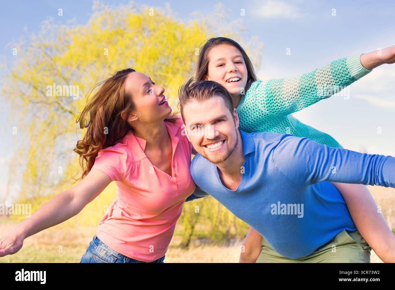 I genitori scherzano con il loro bambino nel prato Foto Stock