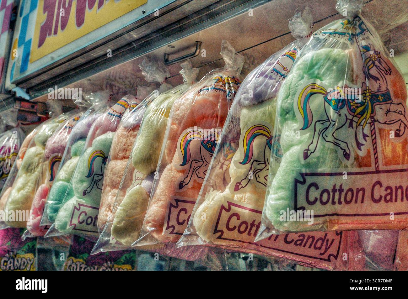 Sacchetti di caramelle di cotone appesi presso uno stand di un fornitore di generi alimentari Foto Stock