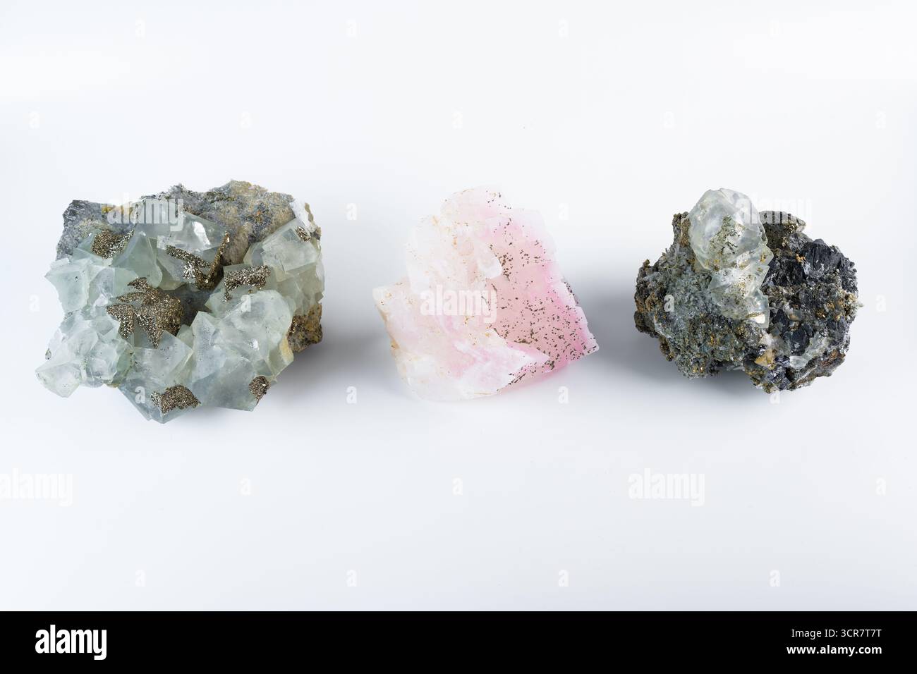 Tre pietre minerali insieme, calcite rosa manganoica, fluorite cubica con pirite e sguardo al piombo galena, fotografato su sfondo bianco. Foto Stock