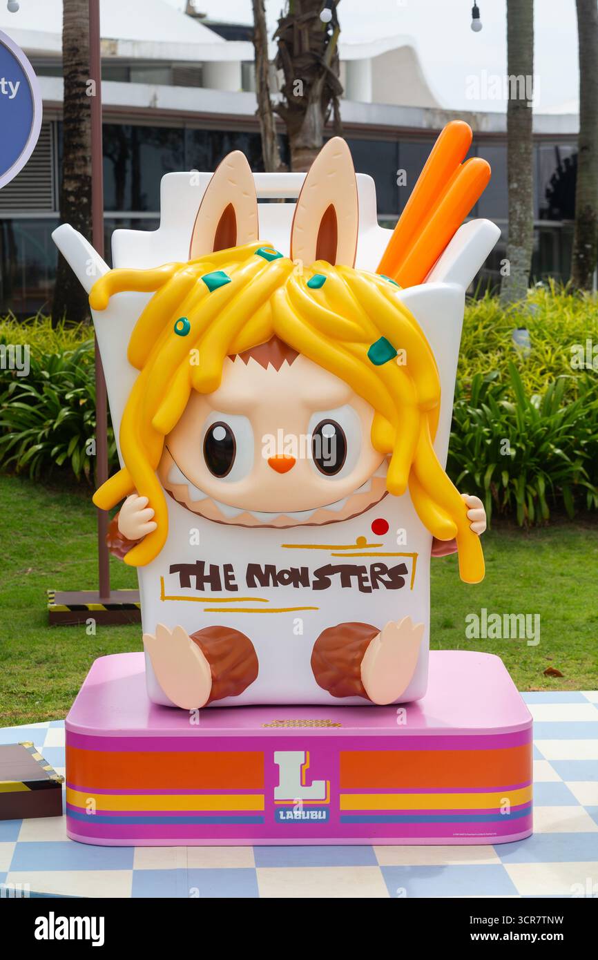 Vista verticale. Labubu Mini Market Pop Up Event, Labubu all'interno di una tazza di spaghetti con bacchette arancioni, zona fotografica, Singapore. Foto Stock