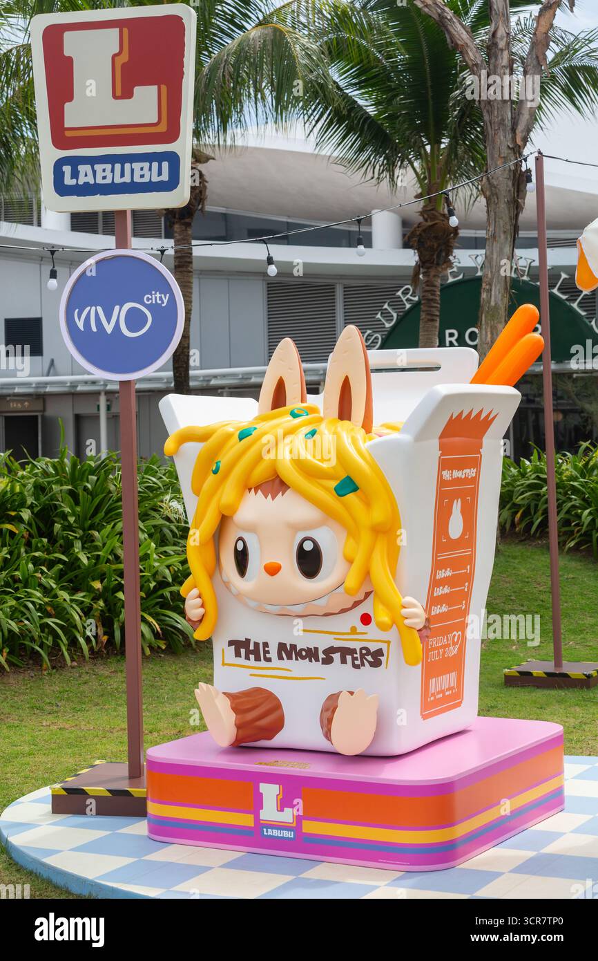 Vista laterale verticale. Labubu Mini Market evento pop-up, mostro carino all'interno di una tazza quadrata con spaghetti sulla testa. Zona fotografica, Singapore. Foto Stock
