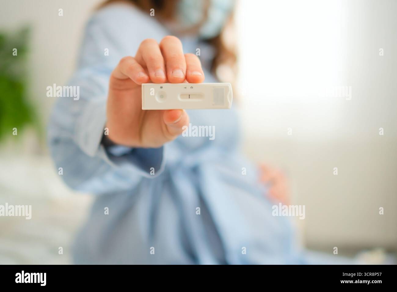 Aspettarsi che la madre visualizzi ansiosamente i risultati dei test PCR a casa. Diagnostica avanzata per le malattie infettive durante il periodo di gravidanza sensibile. Foto Stock