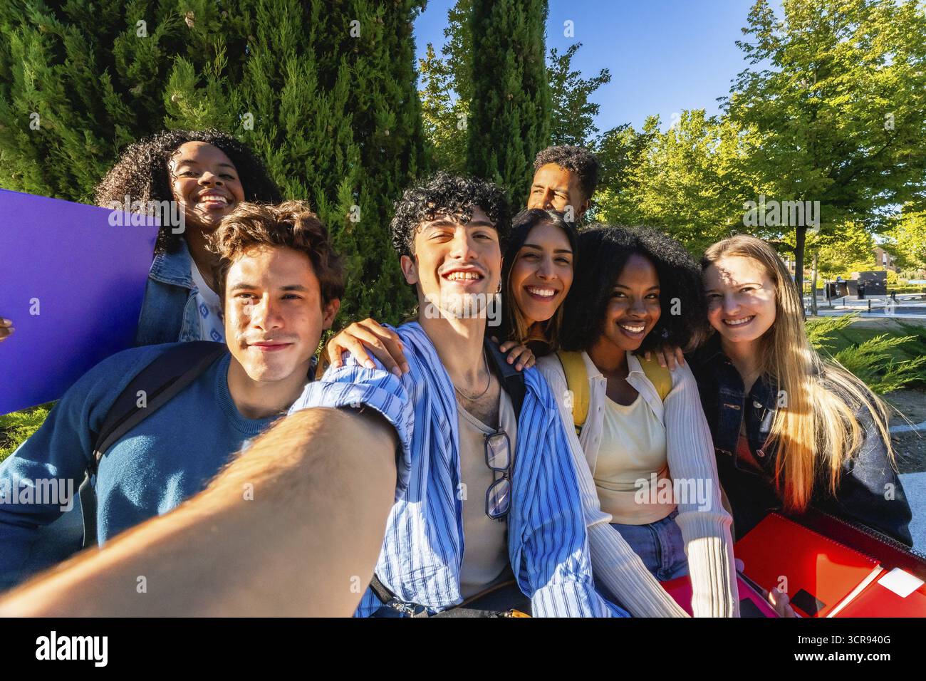 Gruppo eterogeneo di giovani studenti adulti felici sorridenti mentre fanno un selfie di gruppo insieme nel campus universitario, rappresentando l'amicizia e lo stallone moderno Foto Stock
