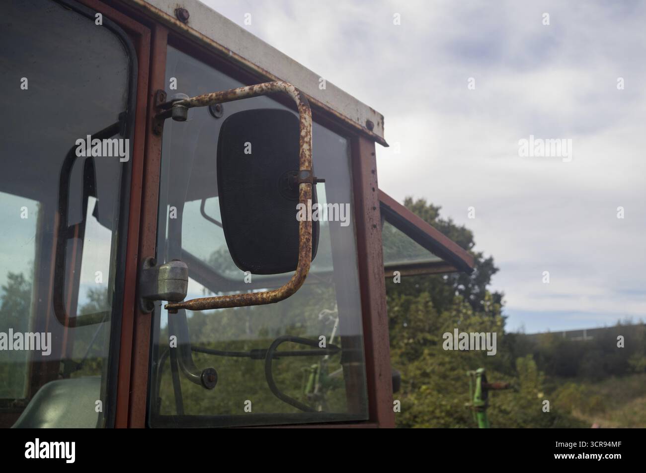 Borken, NRW, Germania, cabina Rusty e specchio laterale di un vecchio trattore agricolo che mostra un decadimento rurale Foto Stock