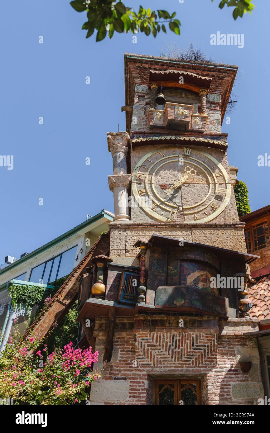 Vista della stravagante torre dell'orologio che si erge alta con i suoi intricati mattoni, i dettagli ornati e un tocco di fascino fiabesco, Tbilisi, Georgia. Foto Stock