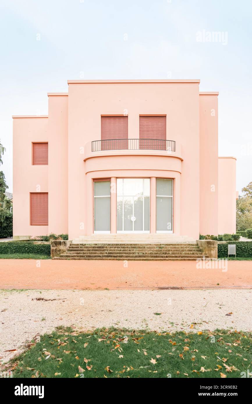Vista frontale della caratteristica facciata rosa salmone e Art Deco della storica Villa Serralves (Casa de Serralves) nei suoi giardini, Porto, Portogallo Foto Stock