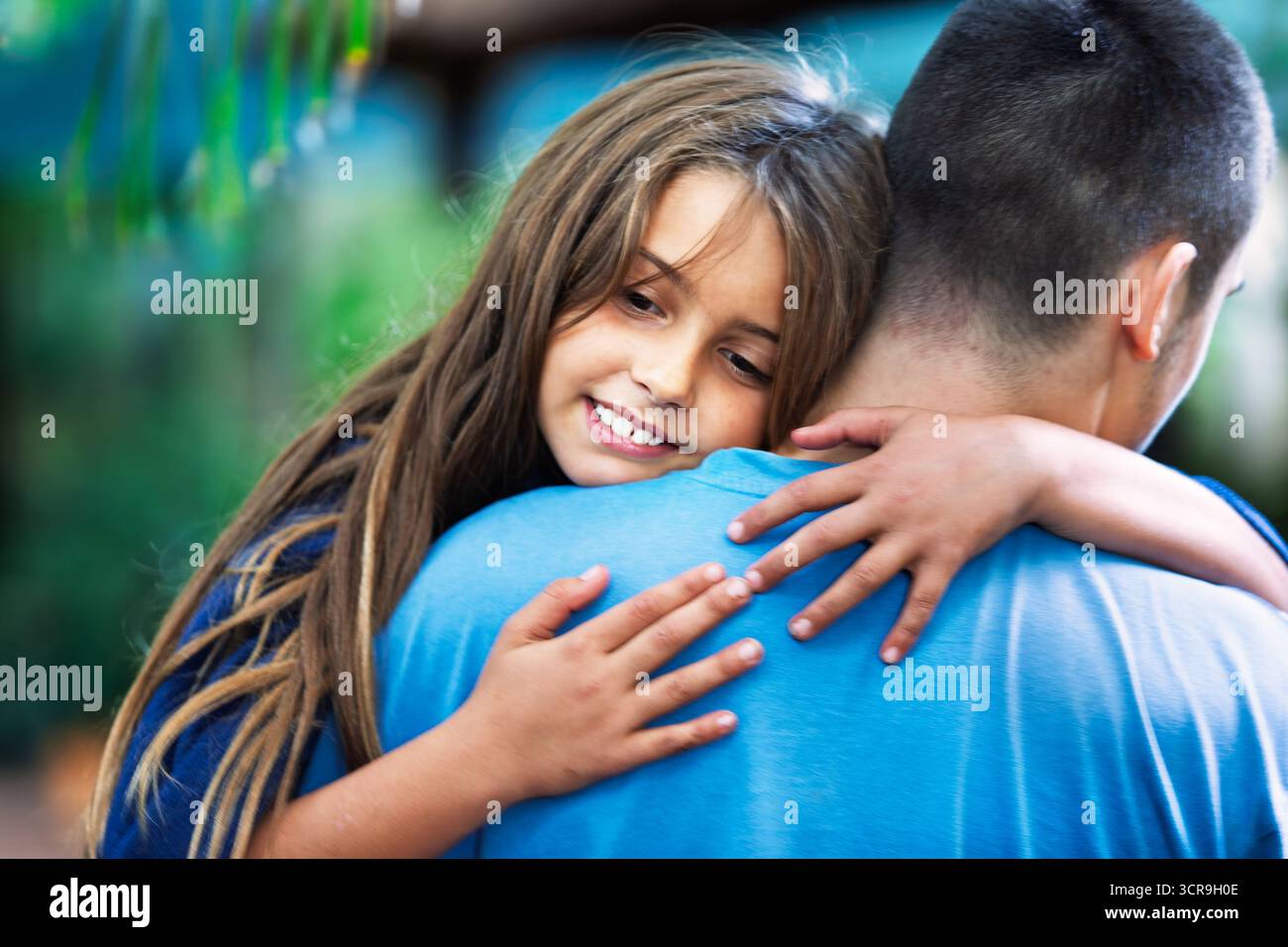 amore fraterno, bambina felice tenuta da suo fratello, testa e spalle ravvicinate, capelli lunghi e mani Foto Stock