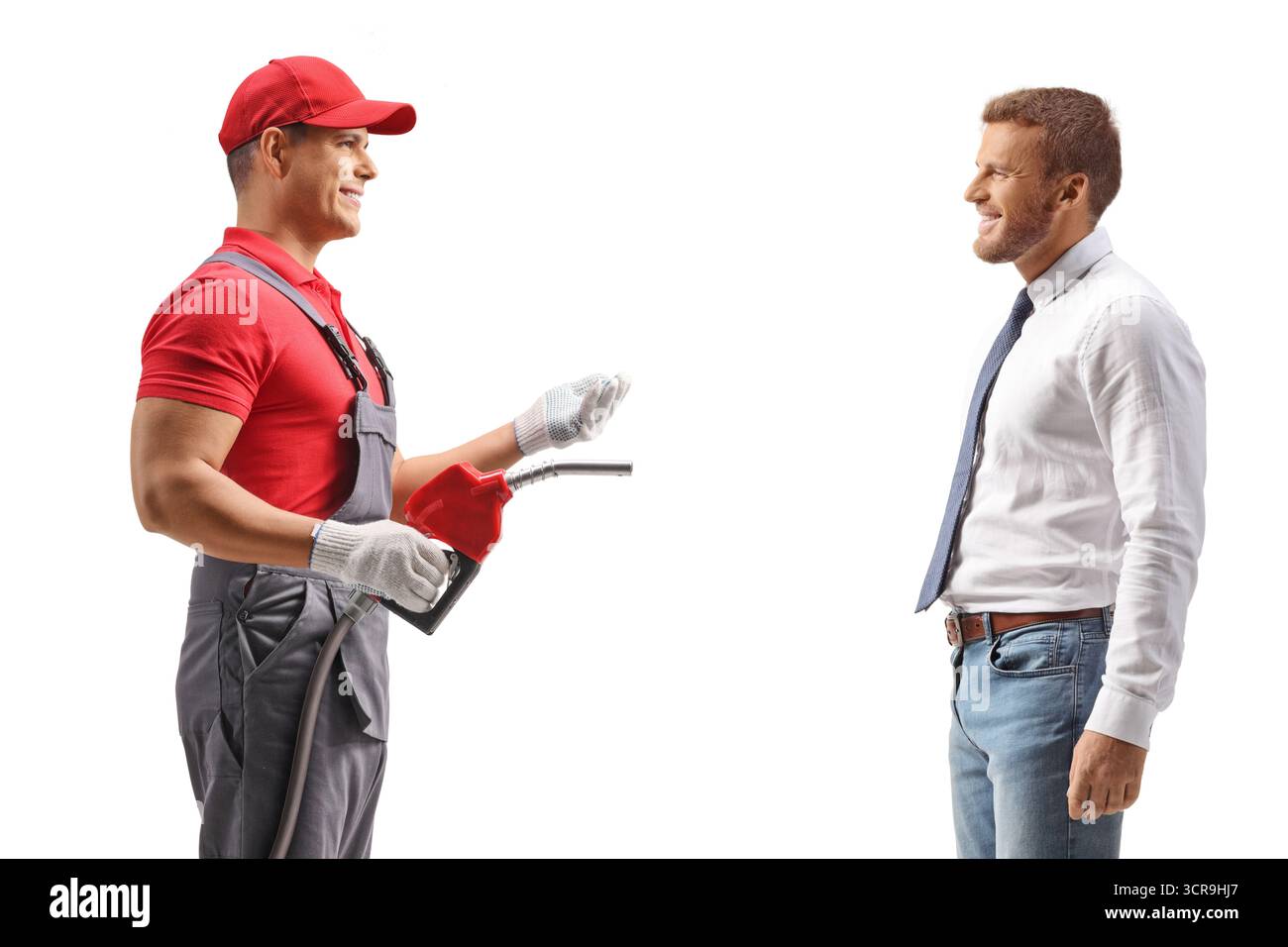 Lavoratore di una stazione di servizio in possesso di una pistola di rifornimento e che parla con un cliente isolato su sfondo bianco Foto Stock