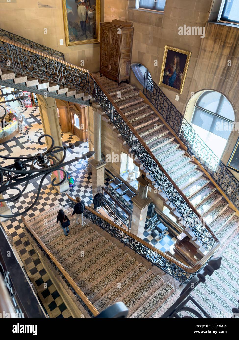 Grande scalinata con ringhiere ornate, dipinti classici e visitatori in un edificio storico all'interno del museo Bowes Barnard Castle, yorkshire Foto Stock