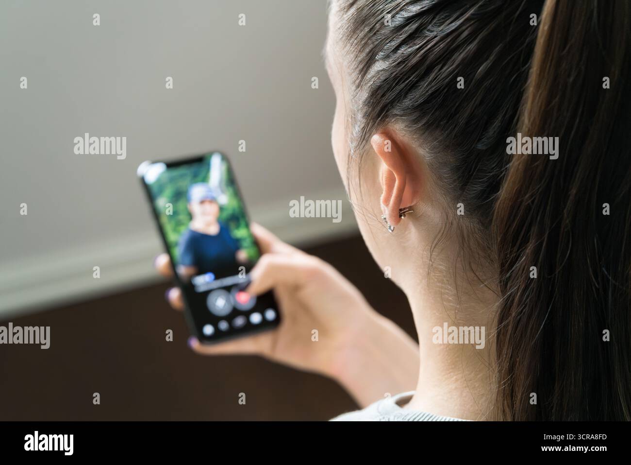 Date truffa dell'app e frode romantica online. Donna che guarda il profilo di un uomo sullo schermo del telefono. Singola o in coppia. Tradimento e infedeltà. Pesce gatto o truffa mobile. Foto Stock