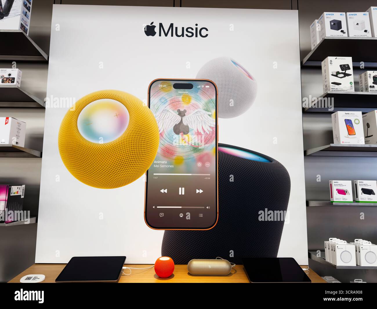 Manchester, Regno Unito - 29 settembre 2025: Scena promozionale Apple Music con altoparlanti intelligenti e iPhone su una parete dello showroom. Foto Stock