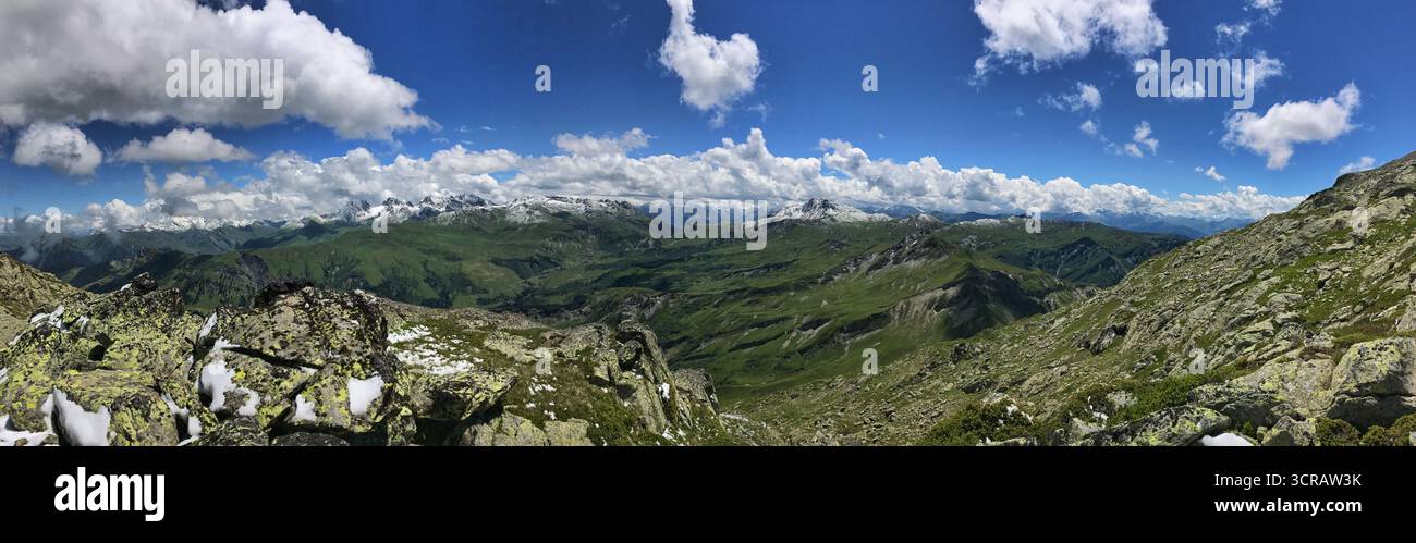 Vista panoramica mozzafiato delle montagne con verdi vallate e nuvole su un cielo azzurro. L'ampio paesaggio trasmette pace e soggezione, con Foto Stock
