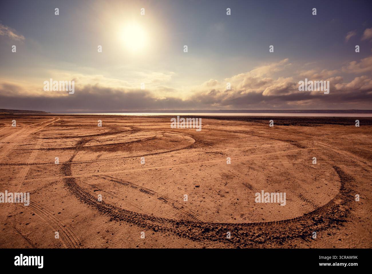 Tracce di auto nella sabbia. Spiaggia di paludi salate al tramonto Foto Stock