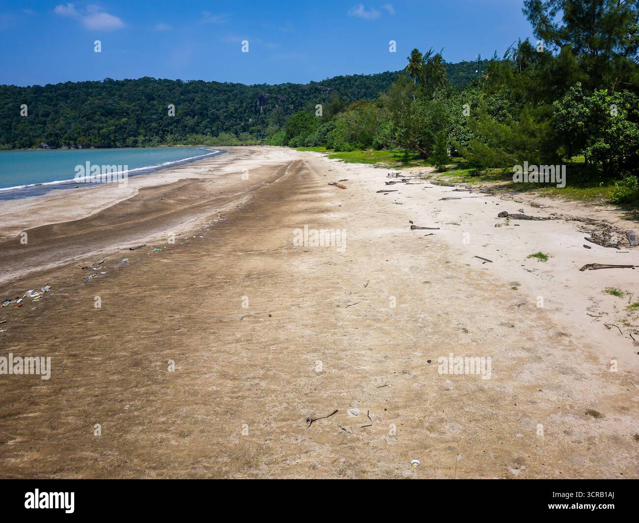 La foresta pluviale tropicale incontra una spiaggia sabbiosa contaminata dai rifiuti di plastica e dall'inquinamento dell'oceano Foto Stock