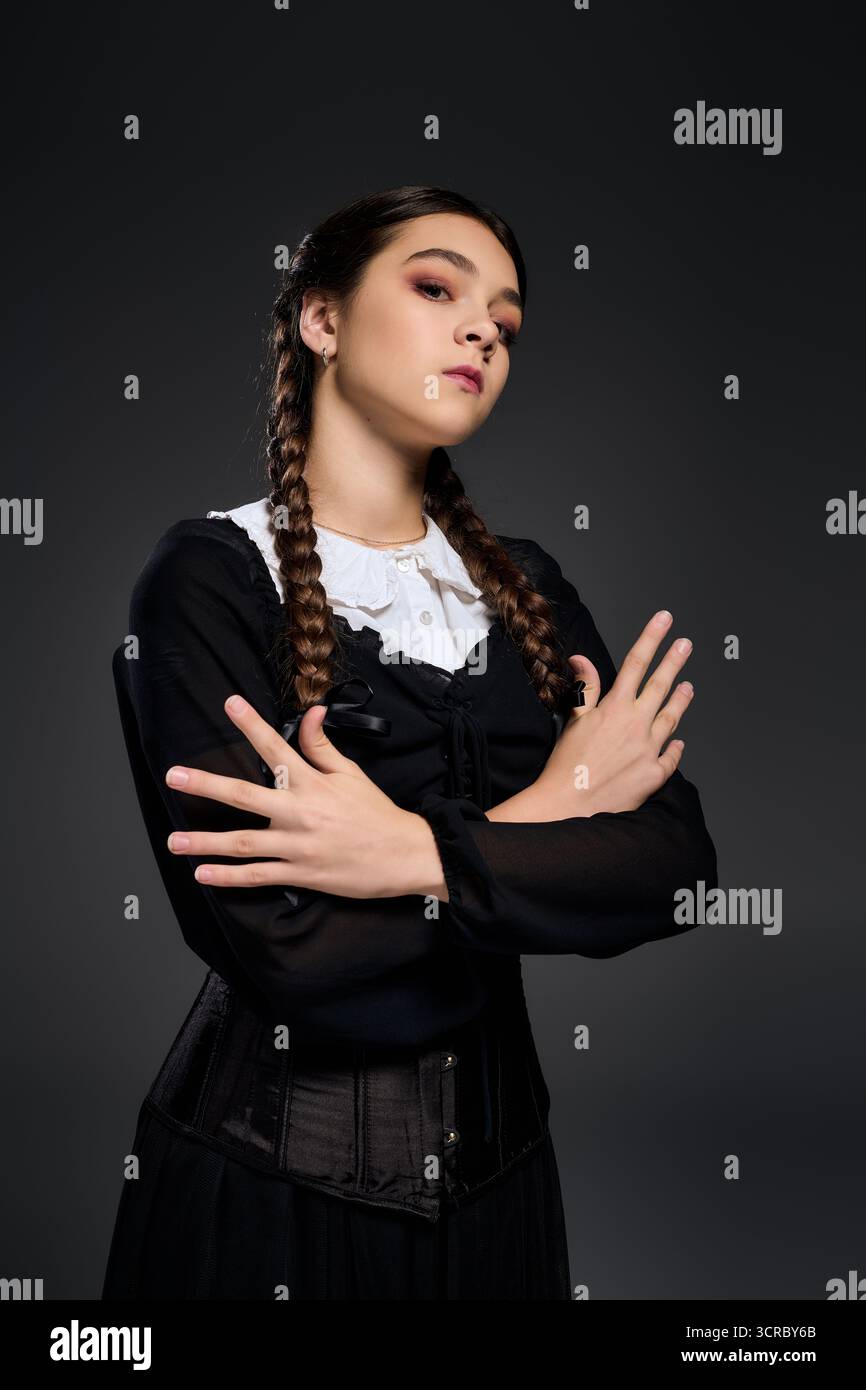 Il bambino vestito come il mercoledì con un abito gotico scuro cattura l'essenza del divertimento della stagione spettrale. Foto Stock