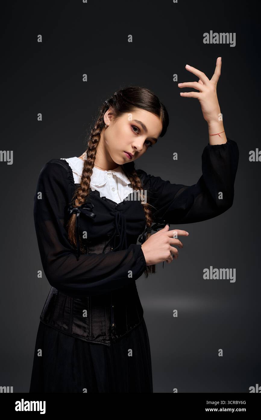 Una ragazza vestita in stile gotico mercoledì posa drammaticamente per un evento a tema Halloween. Foto Stock