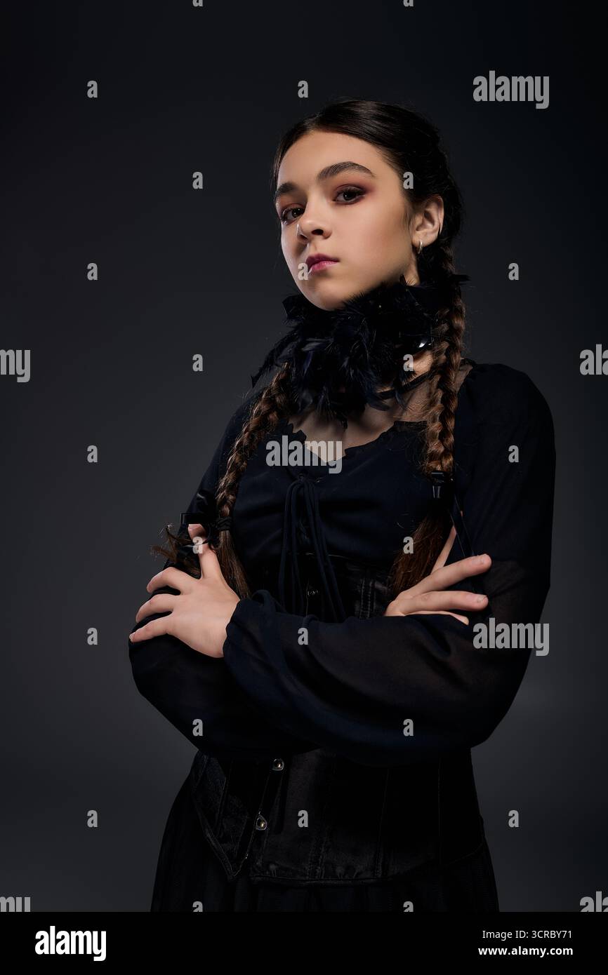 Una ragazza indossa un abito gotico del mercoledì con trecce, incarnando lo spirito di Halloween in ottobre. Foto Stock