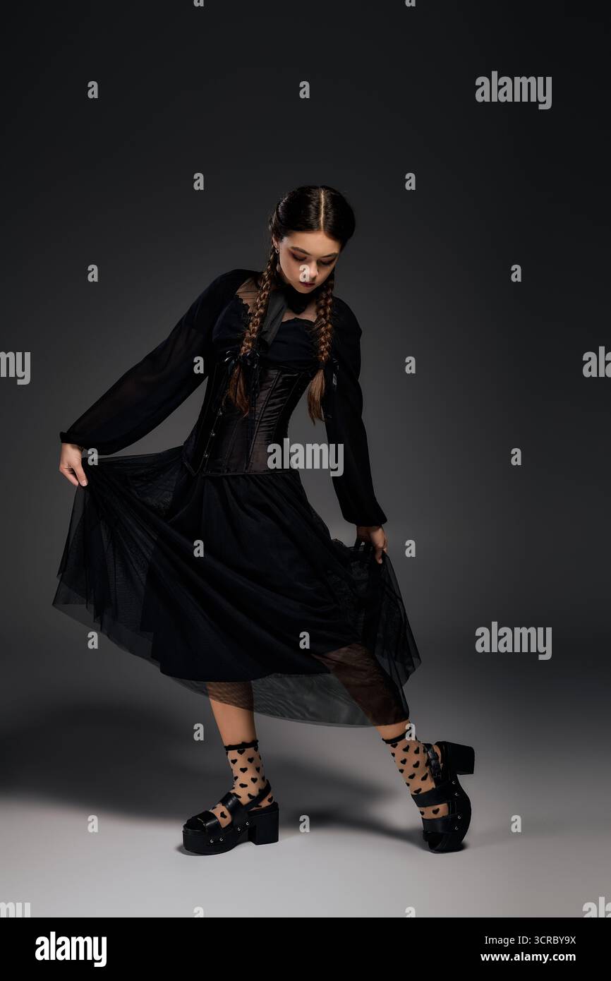 Una ragazza con trecce sfoggia il suo abito gotico per Halloween, incarnando lo spirito spettrale perfetto. Foto Stock