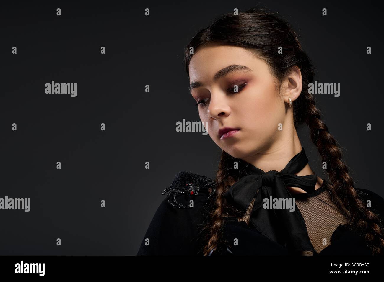 Una ragazza con trecce indossa un abito in stile gotico, abbracciando lo spirito spettrale di Halloween. Foto Stock