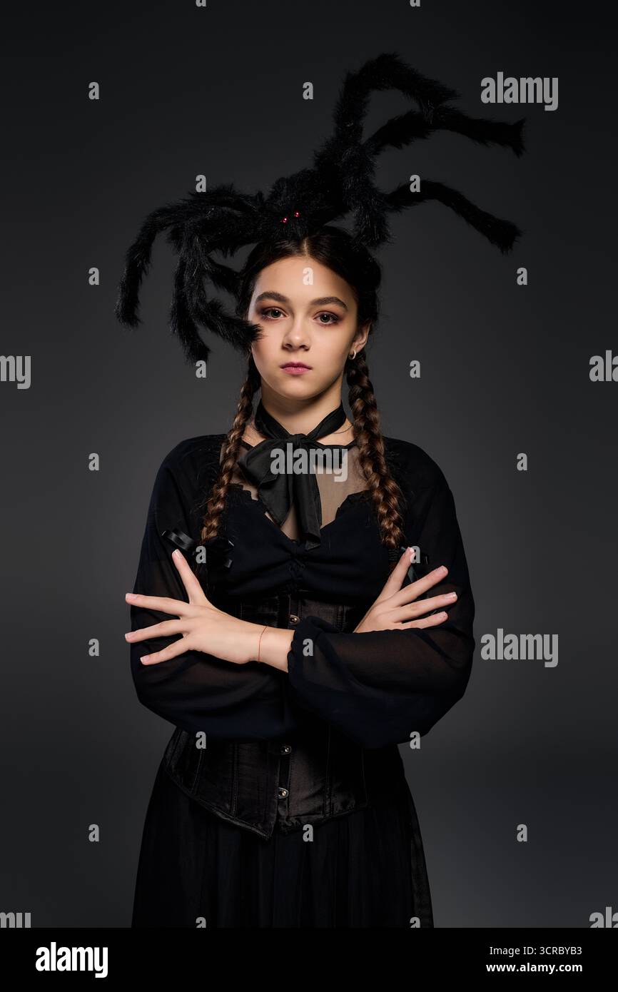 Una ragazza con trecce indossa un abito gotico mercoledì per Halloween, incarnando perfettamente un personaggio spettrale. Foto Stock